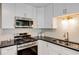 Stylish kitchen featuring white cabinets, granite countertops, stainless steel appliances, and elegant hardware at 263 Keller Dr, Mcdonough, GA 30252
