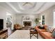 Elegant living room featuring a brick fireplace, hardwood floors, and access to the dining area, perfect for entertaining at 263 Keller Dr, Mcdonough, GA 30252