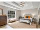 Spacious main bedroom with tray ceiling, a jute rug, and a large window overlooking wooded area at 263 Keller Dr, Mcdonough, GA 30252