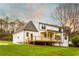 Back exterior featuring a covered deck with ceiling fan and a spacious lawn at 4440 Cannon Rd, Loganville, GA 30052