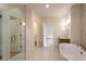 Upscale bathroom with soaking tub, dual vanities and a glass shower, all bathed in natural light at 4440 Cannon Rd, Loganville, GA 30052