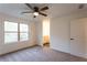 Neutral bedroom offers plush carpet, a ceiling fan, natural light, and a view to an ensuite bathroom at 4440 Cannon Rd, Loganville, GA 30052