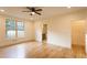 Bright bedroom with wood floors, ceiling fan, window view and a peek into the bathroom at 4440 Cannon Rd, Loganville, GA 30052