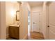 Bright hallway with wood floors and half bath showing wood cabinet, marble countertop, and updated fixtures at 4440 Cannon Rd, Loganville, GA 30052