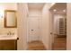 Hallway view with wood flooring, leading to a walk-in closet and featuring a half bath with marble countertop at 4440 Cannon Rd, Loganville, GA 30052