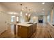 Open-concept living area with a kitchen island, fireplace, and abundant natural light at 4440 Cannon Rd, Loganville, GA 30052