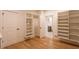 Walk-in closet featuring custom shelving and hanging storage with an ensuite bathroom at 4440 Cannon Rd, Loganville, GA 30052