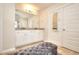 Spacious bathroom with double vanity, large mirror, white cabinets, and cushioned bench at 910 Shannon Mist Dr, Loganville, GA 30052