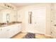 Bright bathroom featuring a double vanity, large mirror and white cabinets at 910 Shannon Mist Dr, Loganville, GA 30052
