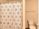 Clean bathroom features a shower with a patterned curtain and a toilet with a neat roll of toilet paper at 910 Shannon Mist Dr, Loganville, GA 30052