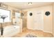 Spa-like bathroom featuring a soaking tub, glass-enclosed shower, and neutral tile flooring at 910 Shannon Mist Dr, Loganville, GA 30052