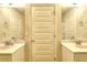 Bright bathroom featuring dual sinks, neutral walls, and a centrally located door and mirrors at 910 Shannon Mist Dr, Loganville, GA 30052
