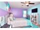 Charming bedroom featuring striped walls, a ceiling fan, and a cozy bed with patterned bedding at 910 Shannon Mist Dr, Loganville, GA 30052