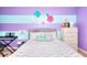 Comfortable bedroom showcases a bed with a patterned comforter, striped walls, and decorative wall art at 910 Shannon Mist Dr, Loganville, GA 30052