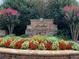 Community entrance featuring a brick sign, landscaping, and colorful flowers at 910 Shannon Mist Dr, Loganville, GA 30052