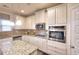 Kitchen featuring white cabinets, granite countertops, a gas stovetop, and stainless steel microwave and oven at 910 Shannon Mist Dr, Loganville, GA 30052