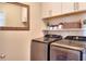Functional laundry room with modern washer and dryer units, storage shelves, and ample countertop space at 910 Shannon Mist Dr, Loganville, GA 30052