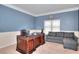Traditional office with a hardwood executive desk, gray couch and carpeted floors at 910 Shannon Mist Dr, Loganville, GA 30052