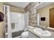 Cozy bathroom with a combined tub and shower, a brick accent wall, and a functional vanity at 2735 Peachtree Walk, Duluth, GA 30096