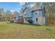 Two story house with blue wood and stone, a short wooden porch, with mature trees and manicured flower beds at 2735 Peachtree Walk, Duluth, GA 30096