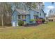 Two story home with a mix of wood and stone exterior, front yard with blue sky and mature trees at 2735 Peachtree Walk, Duluth, GA 30096