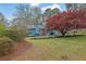 Landscaped front yard featuring a two-story blue home, mature trees, and manicured flowerbeds at 2735 Peachtree Walk, Duluth, GA 30096