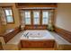 Jetted tub with wood paneling and windows views at 2735 Peachtree Walk, Duluth, GA 30096