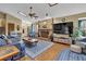 Living room with fireplace, ceiling fan, hardwood floors, and blue furniture sets at 2735 Peachtree Walk, Duluth, GA 30096