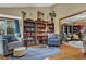 Sitting area with blue rug, built-in bookshelves, hardwood floors, and bright light at 2735 Peachtree Walk, Duluth, GA 30096