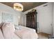 A modern bedroom featuring light hardwood floors, a large window, and a decorative chandelier at 923 Peachtree Ne St # 939, Atlanta, GA 30309