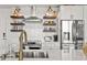 Kitchen featuring stainless steel appliances, open shelving, stylish backsplash, and a modern sink and faucet at 923 Peachtree Ne St # 939, Atlanta, GA 30309