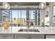 Bright kitchen island with stainless steel sink, bar seating and expansive city views through large windows at 923 Peachtree Ne St # 939, Atlanta, GA 30309