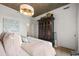 A bedroom with white walls, wood floors, and wardrobe with pink pillows on the bed at 923 Peachtree Ne St # 939, Atlanta, GA 30309