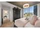 Modern bedroom features a decorative light fixture, wood floors, an armoire and city views at 923 Peachtree Ne St # 939, Atlanta, GA 30309