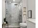 Modern walk-in shower featuring marble tile and a built-in niche for toiletries with brass hardware at 923 Peachtree Ne St # 939, Atlanta, GA 30309