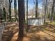 Fenced backyard featuring mature trees and grass with shed for storage at 2943 E Howell Dr, Lawrenceville, GA 30044