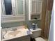Bathroom with a white sink, medicine cabinet, and toilet near a tan shower-tub with patterned curtains at 2943 E Howell Dr, Lawrenceville, GA 30044