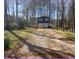 Two-story home with a blue facade, set amongst trees with a two-car garage and lengthy driveway at 2943 E Howell Dr, Lawrenceville, GA 30044