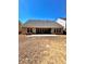 The backyard has a neutral colored home with a patio and is surrounded by dormant foliage and trees at 779 Harvest Brook Dr, Lawrenceville, GA 30043