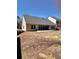 The backyard has a neutral colored home with a patio and is surrounded by dormant foliage and trees at 779 Harvest Brook Dr, Lawrenceville, GA 30043