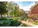 A beautifully landscaped backyard featuring a stone pathway, mature trees, and a glimpse of the lake, perfect for outdoor enjoyment at 1100 Muirfield Ct, Alpharetta, GA 30005