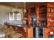 A stylish home bar with custom wood cabinetry, unique lighting, and luxurious seating offers great entertaining space at 1100 Muirfield Ct, Alpharetta, GA 30005
