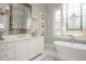 Bathroom with marble countertops, dual sinks, decorative window, and mirrored accents creating a luxurious space at 1100 Muirfield Ct, Alpharetta, GA 30005