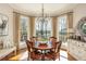 Charming dining room with bay window views and a stylish chandelier over the wood table at 1100 Muirfield Ct, Alpharetta, GA 30005