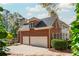 A beautiful brick home with a three-car garage and lush landscaping, offering curb appeal and a welcoming atmosphere at 1100 Muirfield Ct, Alpharetta, GA 30005