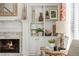 Close-up of the fireplace with white mantel, marble surround, and built-in shelving with decorative items at 1100 Muirfield Ct, Alpharetta, GA 30005