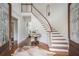 Elegant foyer with hardwood floors, curved staircase, and decorative rug creating a grand entrance at 1100 Muirfield Ct, Alpharetta, GA 30005