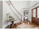 Bright foyer showcasing staircase, beautiful hardwood floors, and striking front door at 1100 Muirfield Ct, Alpharetta, GA 30005