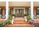 Charming entryway with brick steps, white columns, and floral arrangements offering a warm and inviting welcome at 1100 Muirfield Ct, Alpharetta, GA 30005