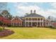 Stately brick home with a large front lawn, covered balcony, and double front doors exuding curb appeal at 1100 Muirfield Ct, Alpharetta, GA 30005